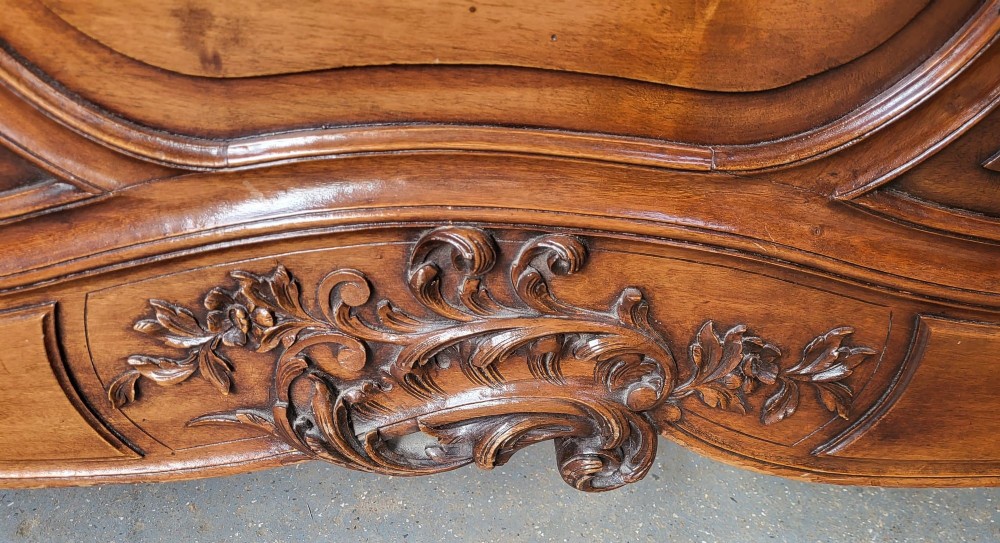 Carved wooden French Louis XV style king size bedstead with a high headboard and matching footboard featuring rocaille scrollwork and cabriole feet. View III