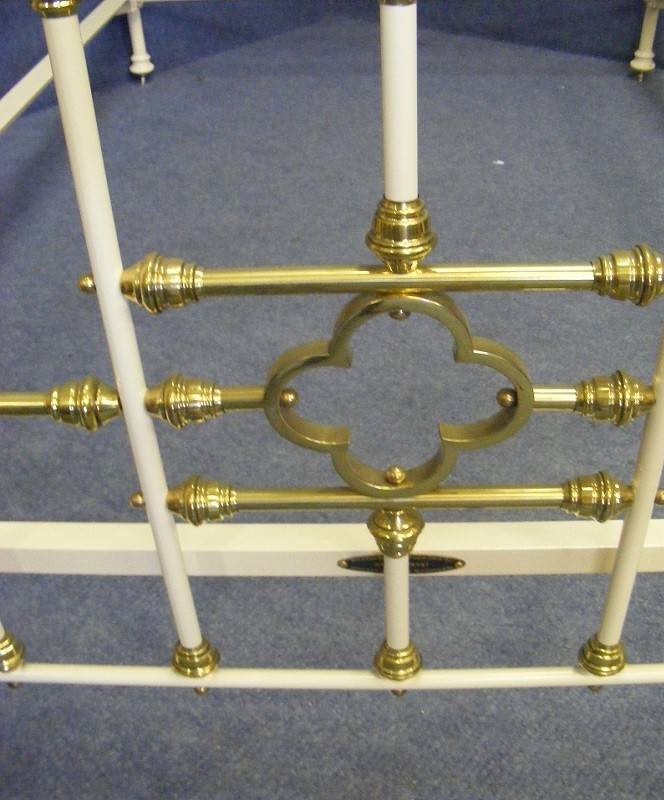 A Victorian small double bedstead featuring a cream-painted iron frame with ornate polished brass rails, finials, and scrollwork. View II