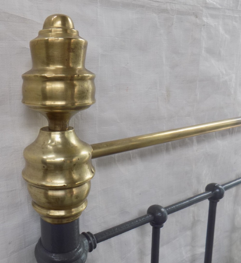 A Victorian grey painted iron bedstead featuring vertical spindles, horizontal brass top rails, and decorative brass corner finials. View IV