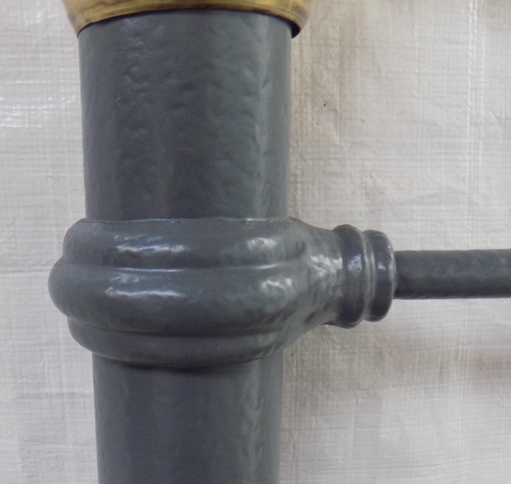 A Victorian grey painted iron bedstead featuring vertical spindles, horizontal brass top rails, and decorative brass corner finials. View VI