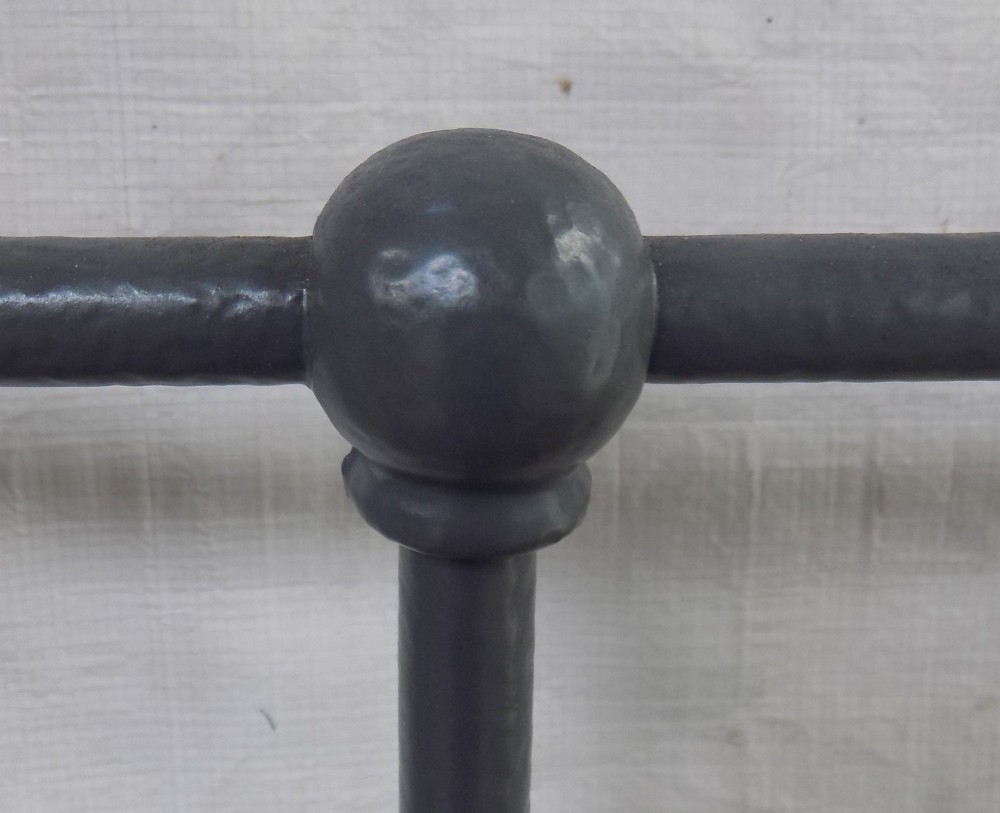A Victorian grey painted iron bedstead featuring vertical spindles, horizontal brass top rails, and decorative brass corner finials. View VII