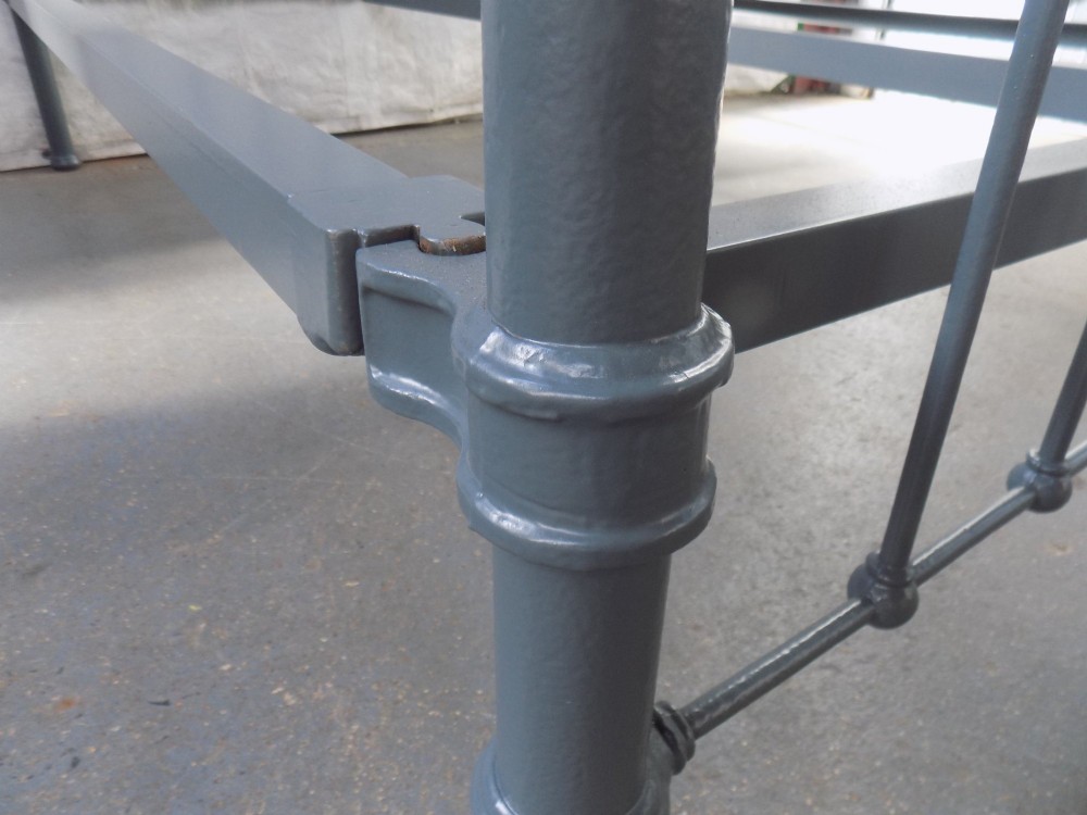 A Victorian grey painted iron bedstead featuring vertical spindles, horizontal brass top rails, and decorative brass corner finials. View VIII