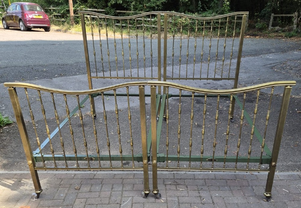 A pair of late Victorian brass single bedsteads featuring vertical spindles with turned detailing and curved top rails. View II