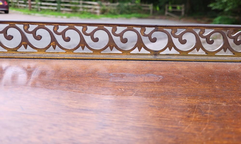 A 19th-century flame mahogany secretaire a abattant featuring carved scrollwork, diamond veneer patterns, lower cupboards with rosette medallions, and a brass gallery top. View VI