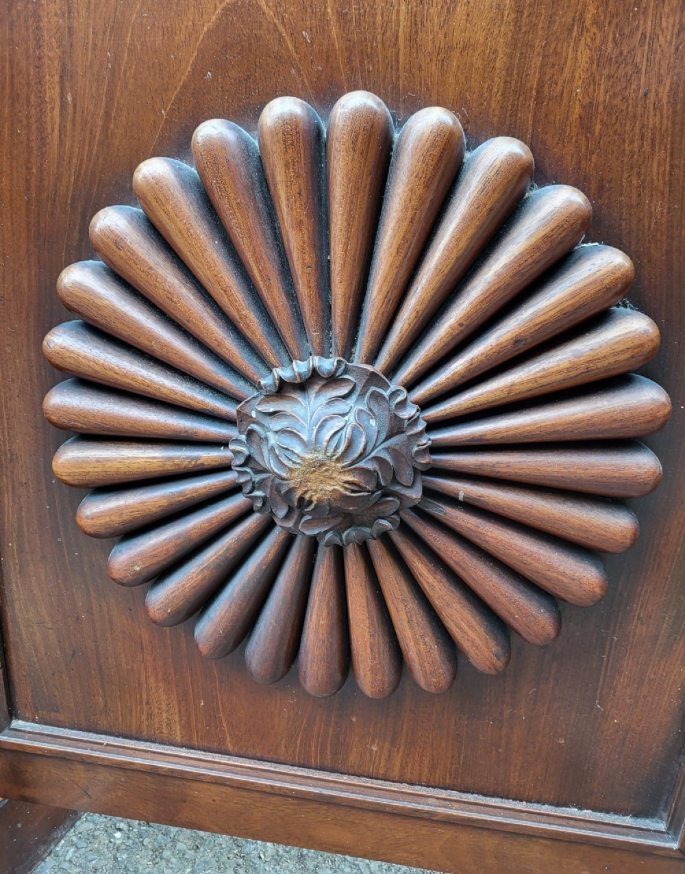 A 19th-century flame mahogany secretaire a abattant featuring carved scrollwork, diamond veneer patterns, lower cupboards with rosette medallions, and a brass gallery top. View VII