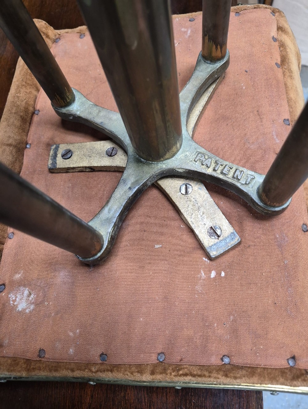 A Victorian brass-framed harpist stool with a buttoned warm brown velvet seat and splayed legs. View IV