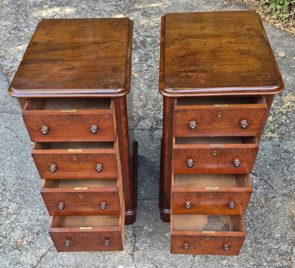 A pair of Victorian mahogany bedside chests featuring four drawers each with turned wooden knobs and a solid plinth base. View II