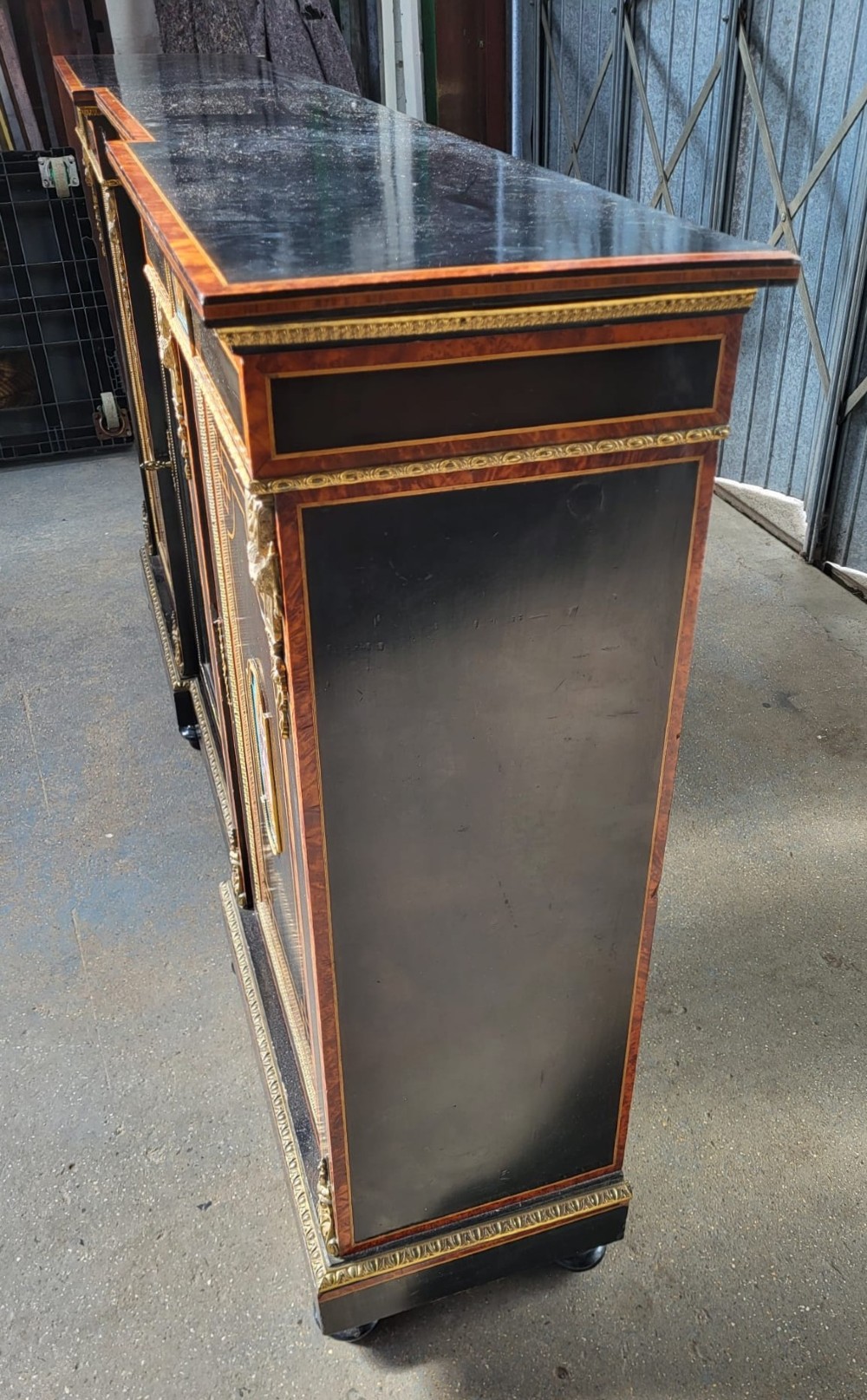 Victorian ebonised breakfront three-door side cabinet featuring gilt ormolu mounts, marquetry inlay, porcelain plaques, and a central glazed display section. View III