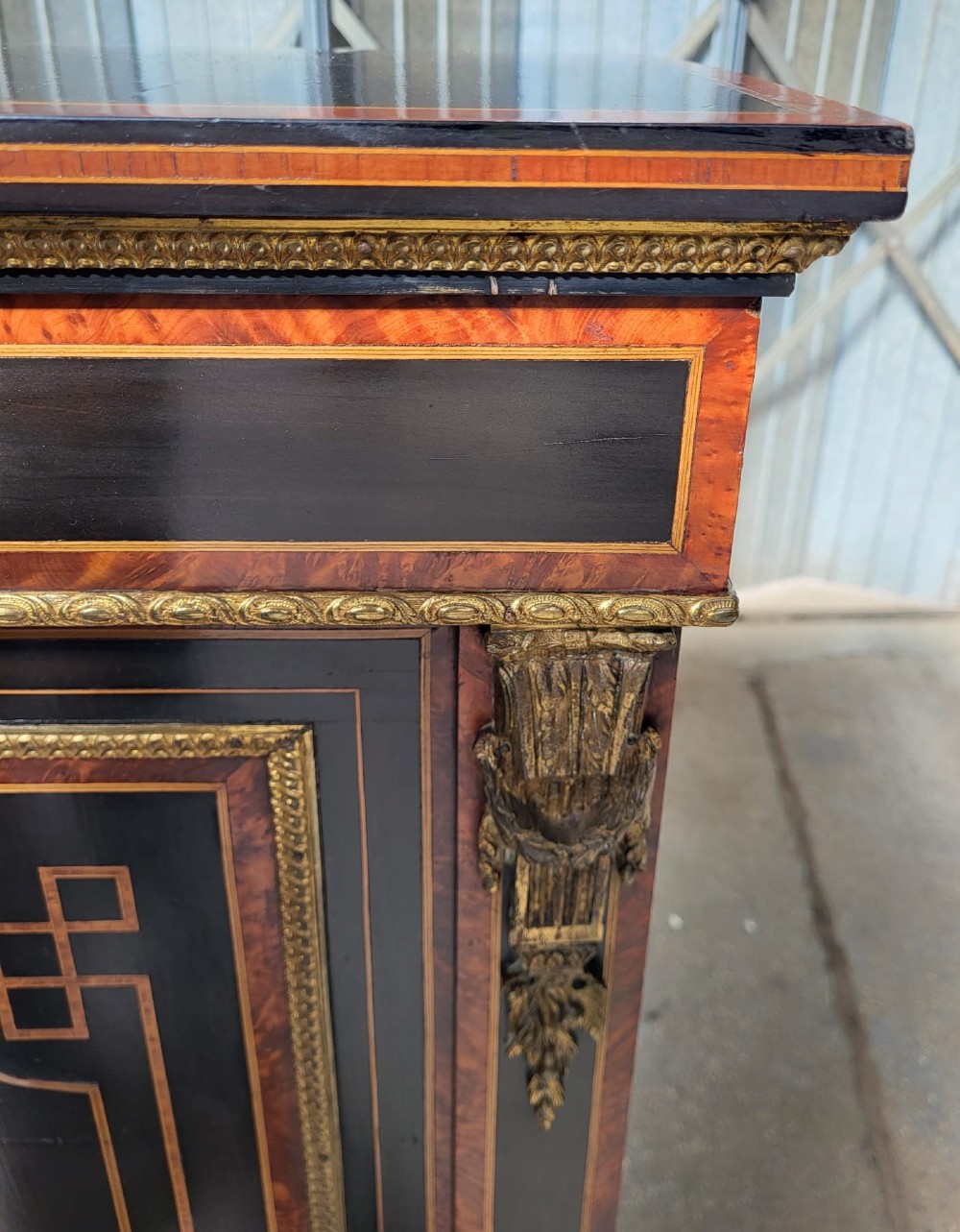 Victorian ebonised breakfront three-door side cabinet featuring gilt ormolu mounts, marquetry inlay, porcelain plaques, and a central glazed display section. View IV