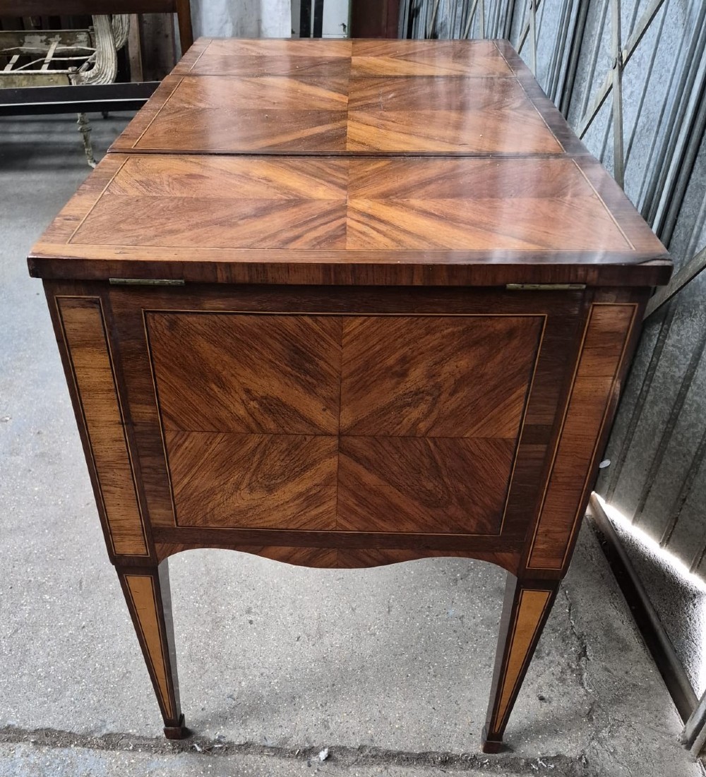 A 19th-century French inlaid kingwood and walnut poudreuse with a three-part geometric parquetry top, shaped kneehole apron, brass mounts, and tapered square legs. View IV