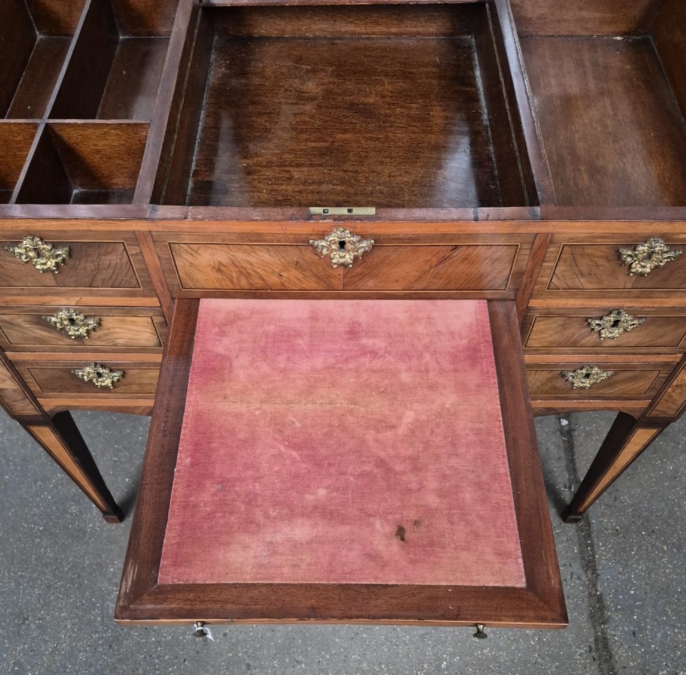 A 19th-century French inlaid kingwood and walnut poudreuse with a three-part geometric parquetry top, shaped kneehole apron, brass mounts, and tapered square legs. View XI