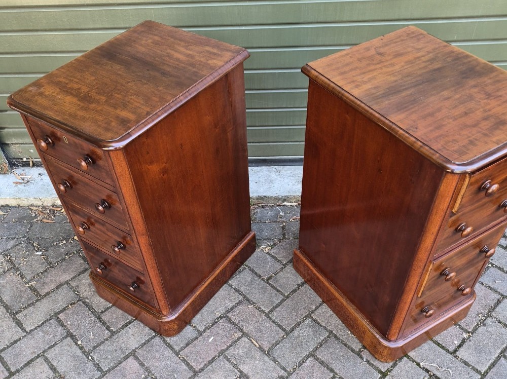 A matching pair of tall Victorian mahogany bedside chests with four drawers each, round wooden knobs, and solid plinth bases. View III