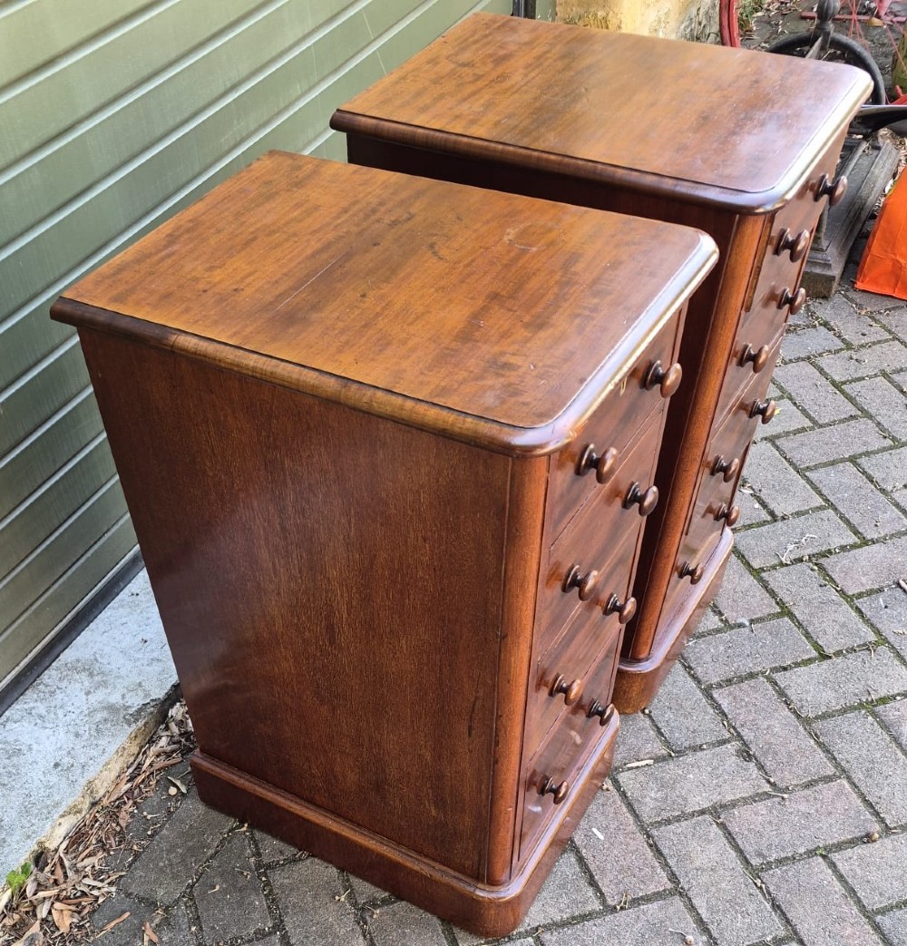 A matching pair of tall Victorian mahogany bedside chests with four drawers each, round wooden knobs, and solid plinth bases. View IV