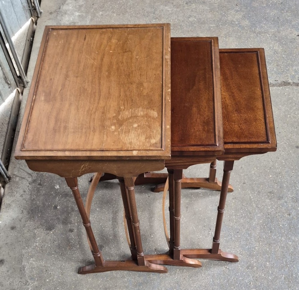 A set of three nested Edwardian mahogany side tables featuring rectangular tops with moulded edges and slender ring-turned legs. View III