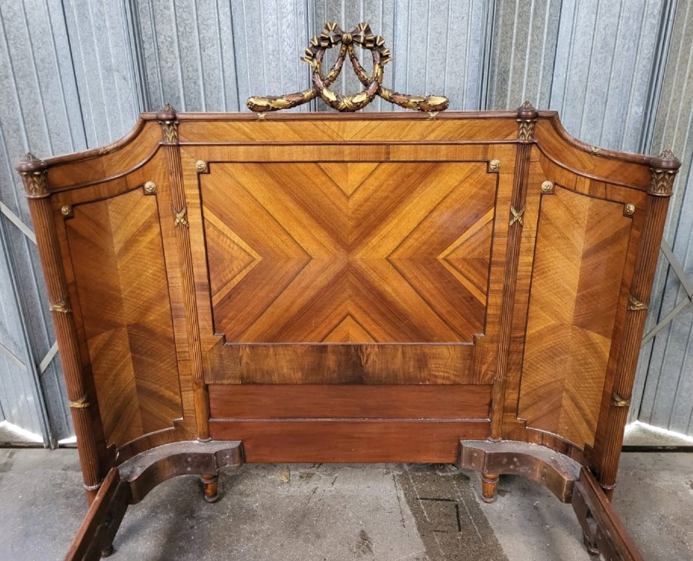 A 19th-century French king-size bedstead made from quarter-veneered walnut with carved cresting and gilt bronze mounts on the headboard and footboard. View III