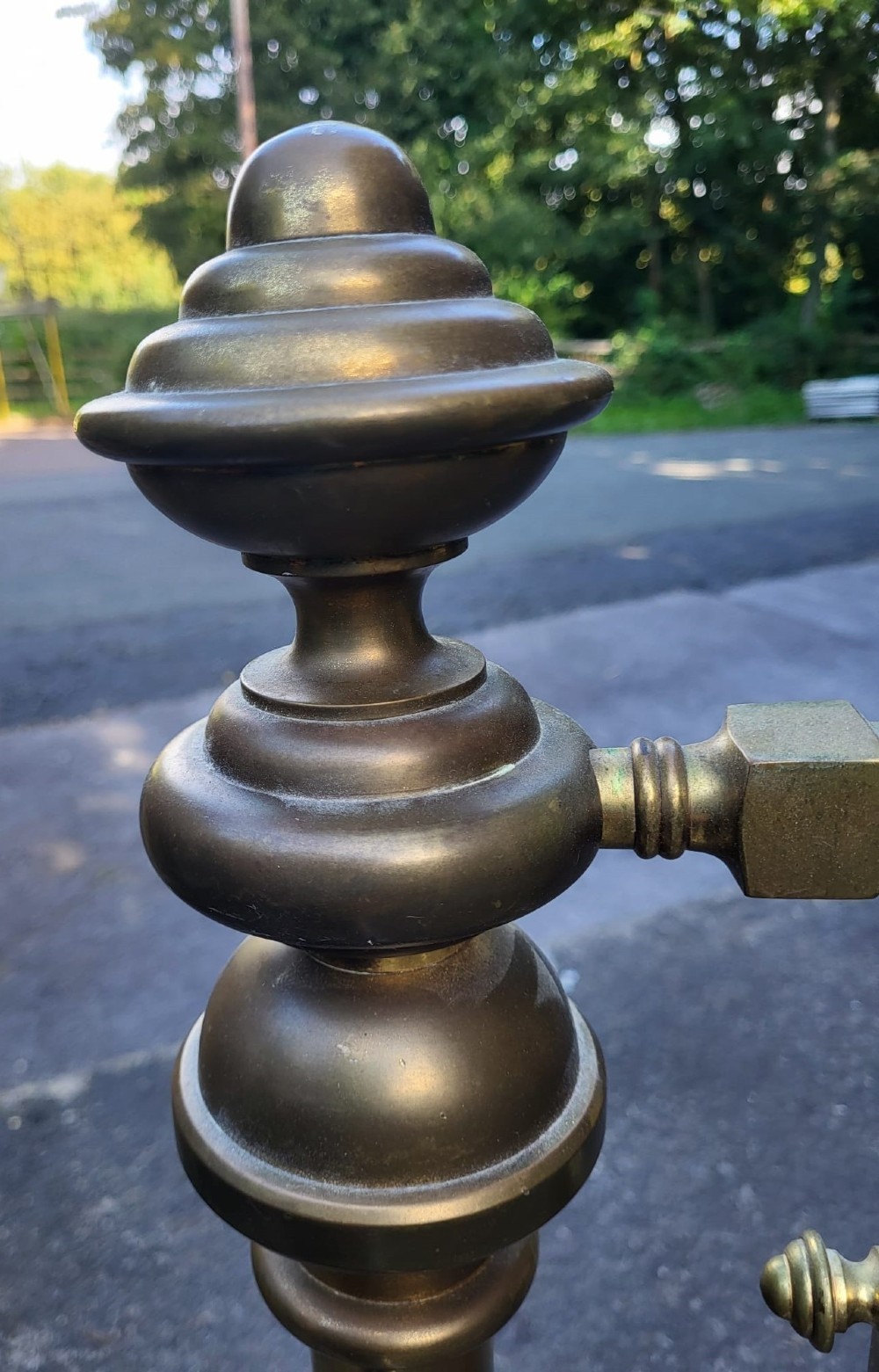 A Victorian Arts and Crafts king size brass bedstead featuring turned corner posts with finials, vertical geometric spindles, and central ring accents. View IV