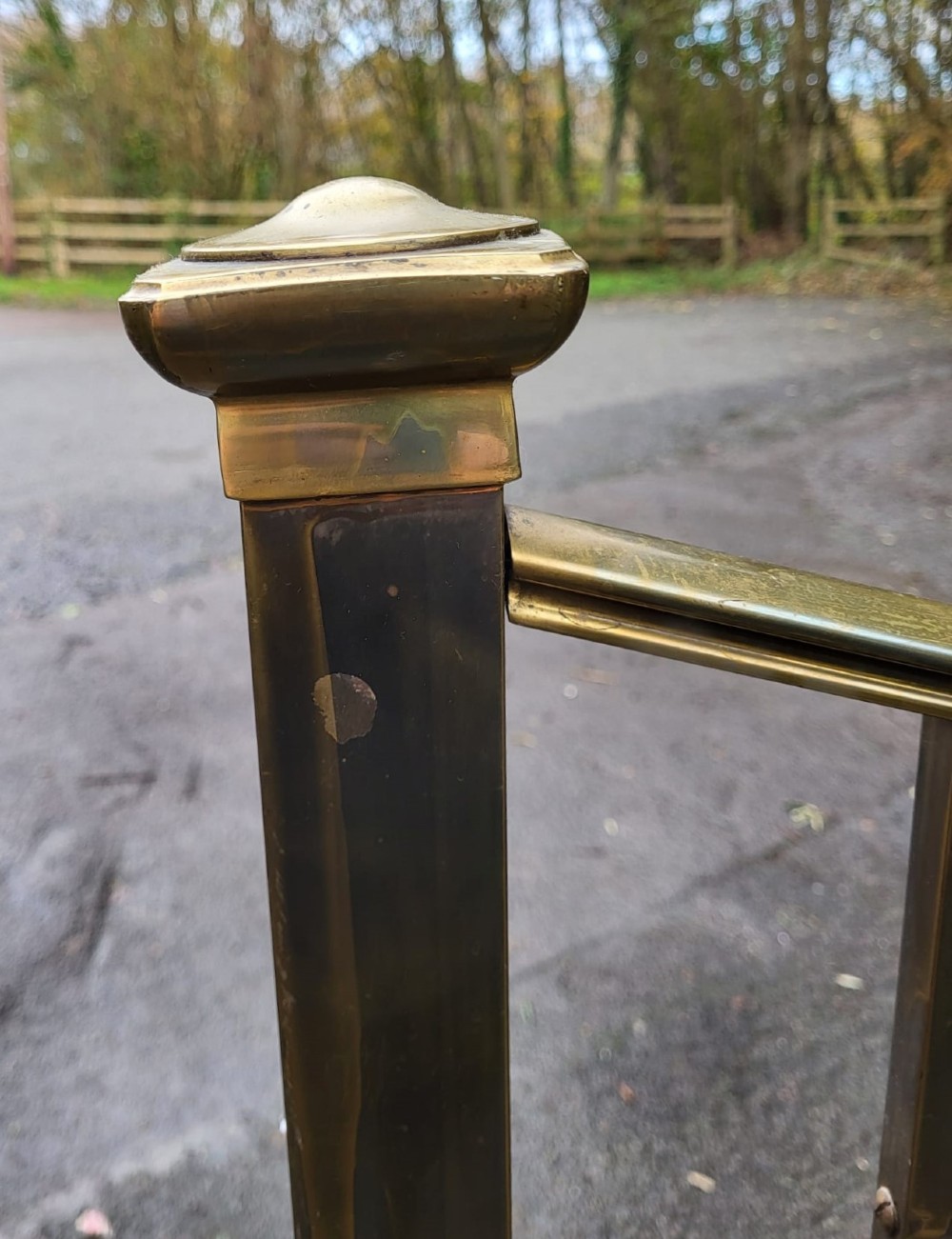 A Victorian brass single bedstead featuring a curved top rail, vertical spindles, square corner posts, and finials. View III