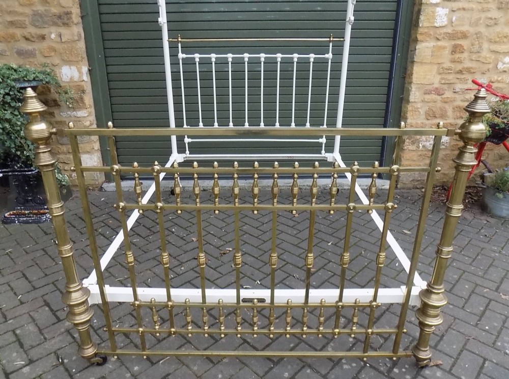 A Victorian brass and painted iron king size half tester bedstead featuring turned brass spindles, decorative finials, and an overhead frame. View II