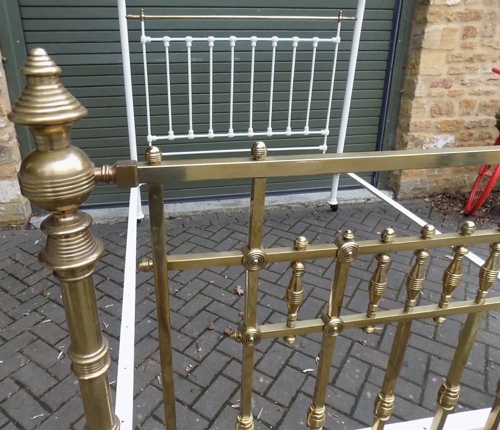 A Victorian brass and painted iron king size half tester bedstead featuring turned brass spindles, decorative finials, and an overhead frame. View IV