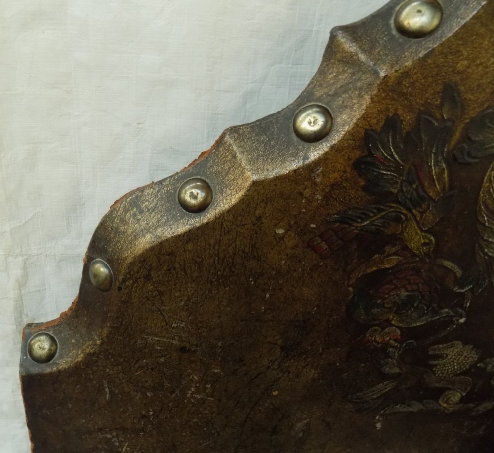 A pair of matching single bedsteads upholstered in aged brown hand-painted leather with brass stud trimming and arched tops. View VI
