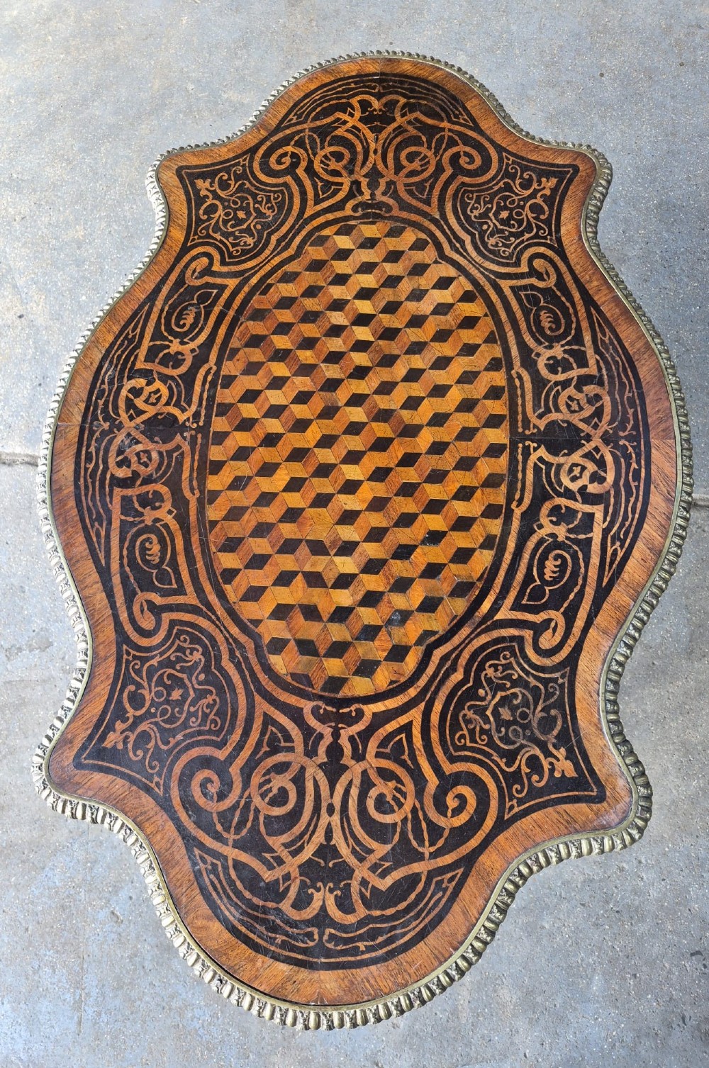 A 19th-century French kingwood centre table featuring a shaped serpentine top with geometric parquetry inlay, scroll marquetry borders, ormolu mounts, and cabriole legs. View II