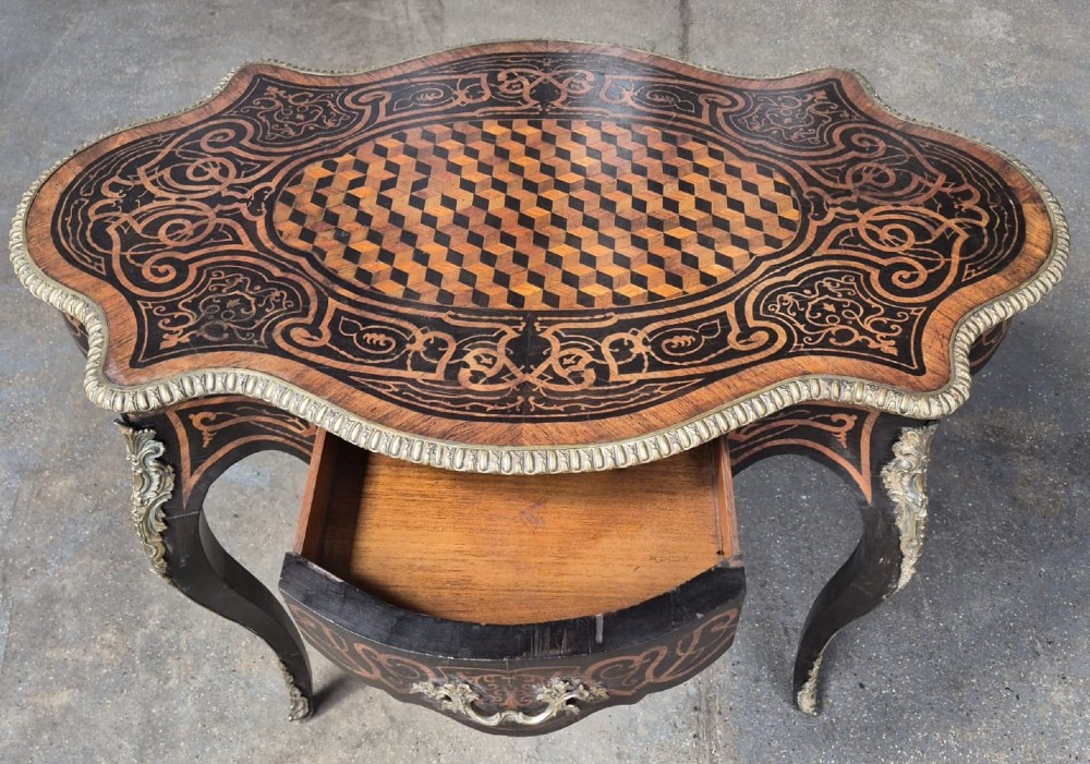 A 19th-century French kingwood centre table featuring a shaped serpentine top with geometric parquetry inlay, scroll marquetry borders, ormolu mounts, and cabriole legs. View III