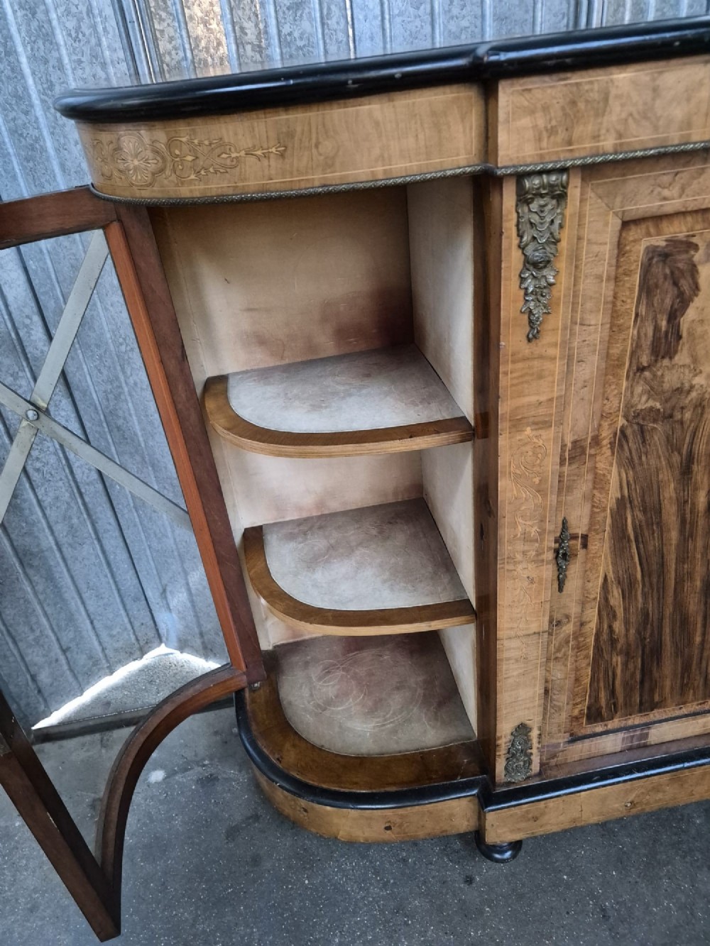 A Victorian burr walnut credenza featuring a central door with inlaid marquetry, ebonised top and base mouldings, metal mounts, and two curved glass side compartments. View III