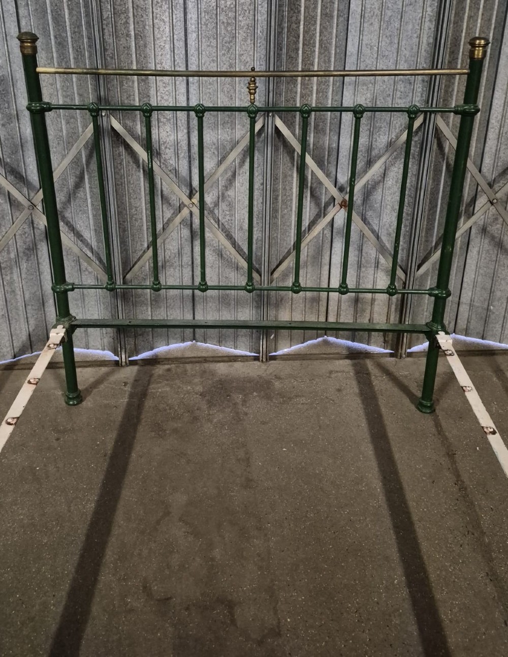 A Victorian Art Nouveau double bedstead featuring dark green painted iron frames, stylized heart-shaped motifs, and brass top rails with finials. View II