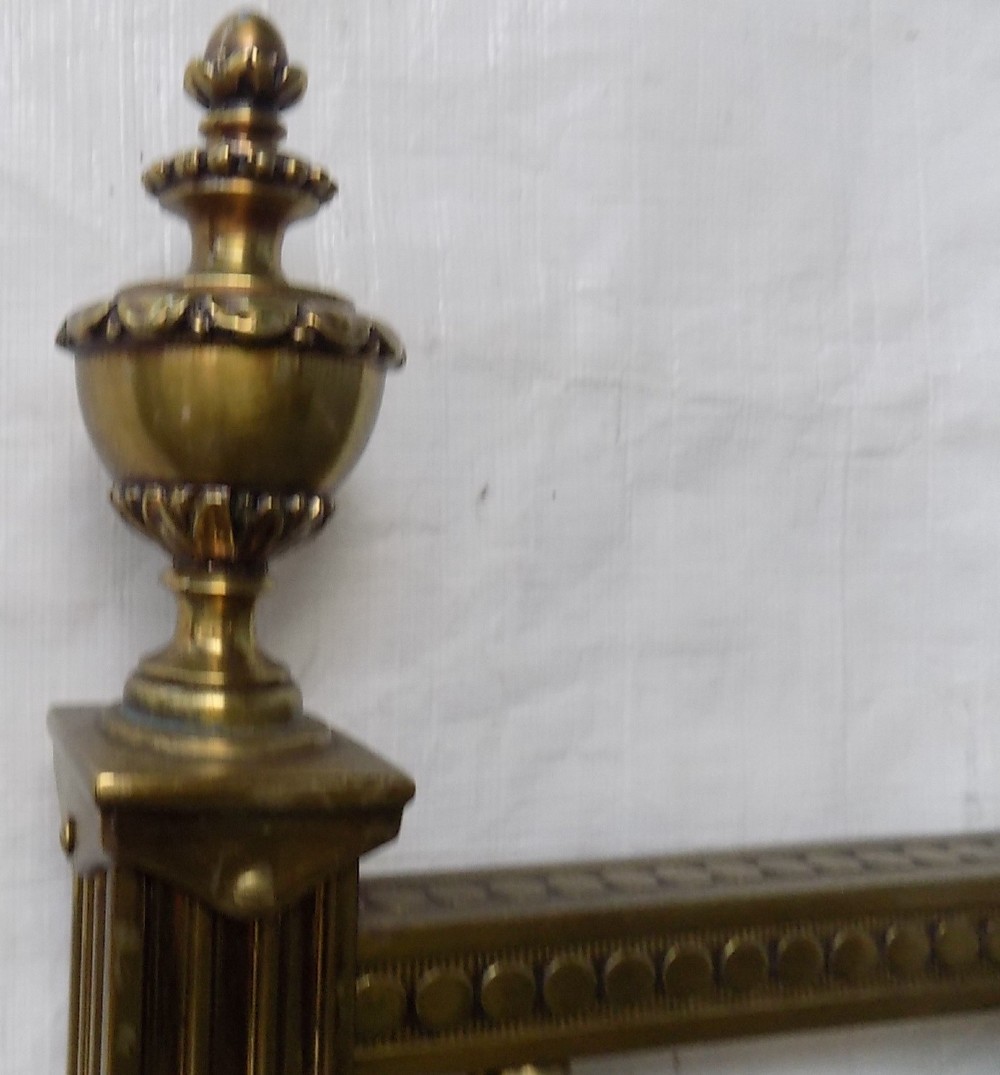 A pair of late Victorian brass-framed twin bedsteads featuring polished brass rails, top drapery swags, urn finials, and central mahogany timber panels with decorative brass plaques. View IV