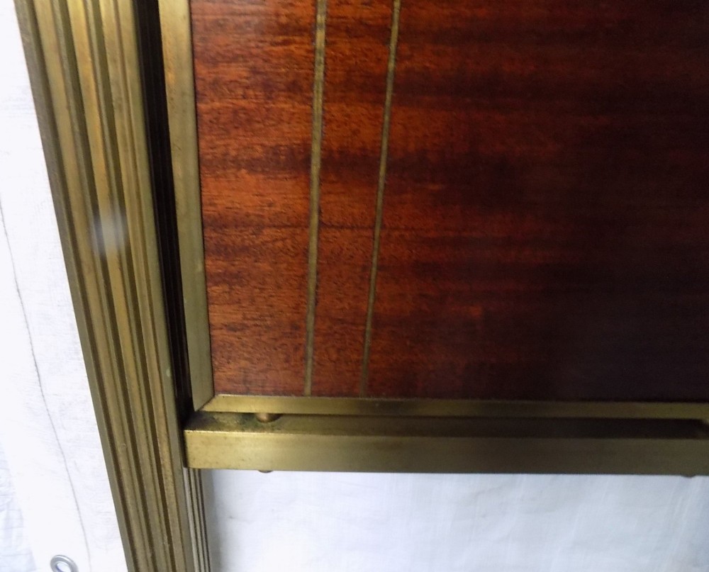 A pair of late Victorian brass-framed twin bedsteads featuring polished brass rails, top drapery swags, urn finials, and central mahogany timber panels with decorative brass plaques. View VII