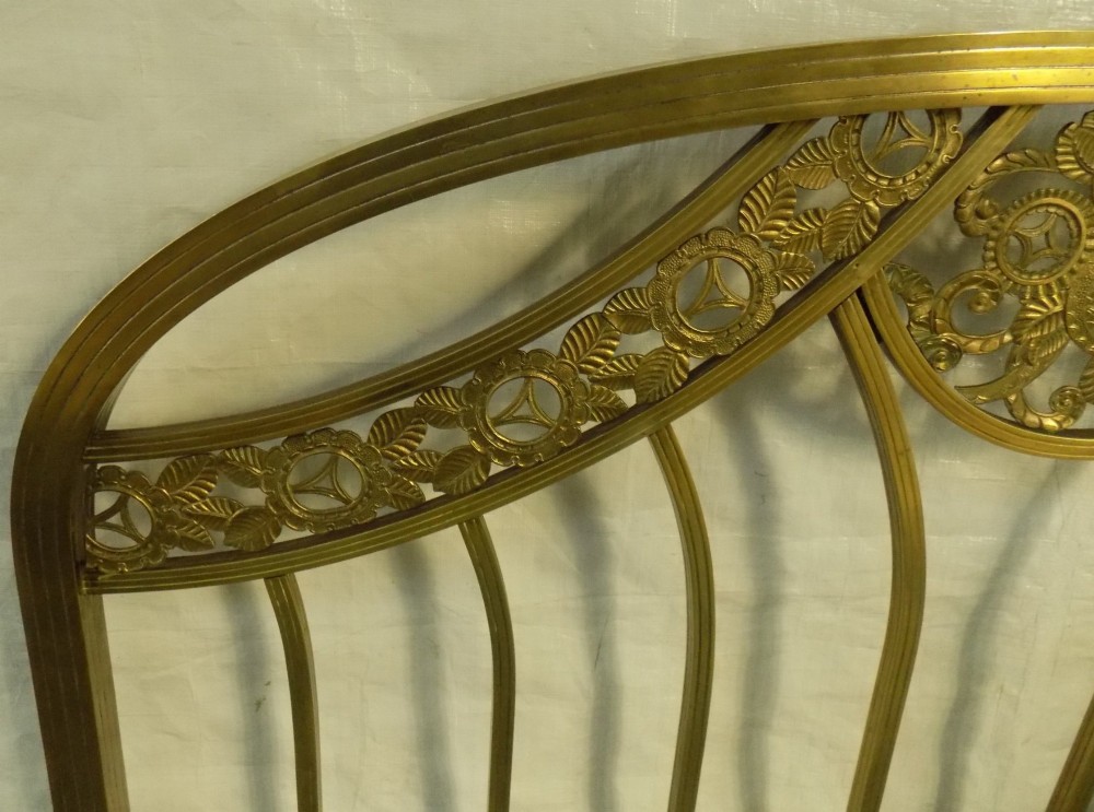 A late 19th-century brass bedstead with an arched headboard and footboard featuring detailed scrollwork and vertical spindles. View V