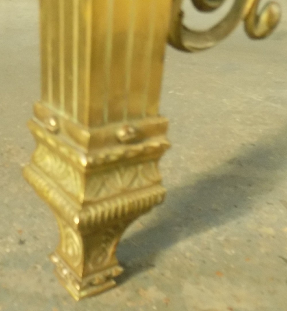 A late 19th-century brass bedstead with an arched headboard and footboard featuring detailed scrollwork and vertical spindles. View IX