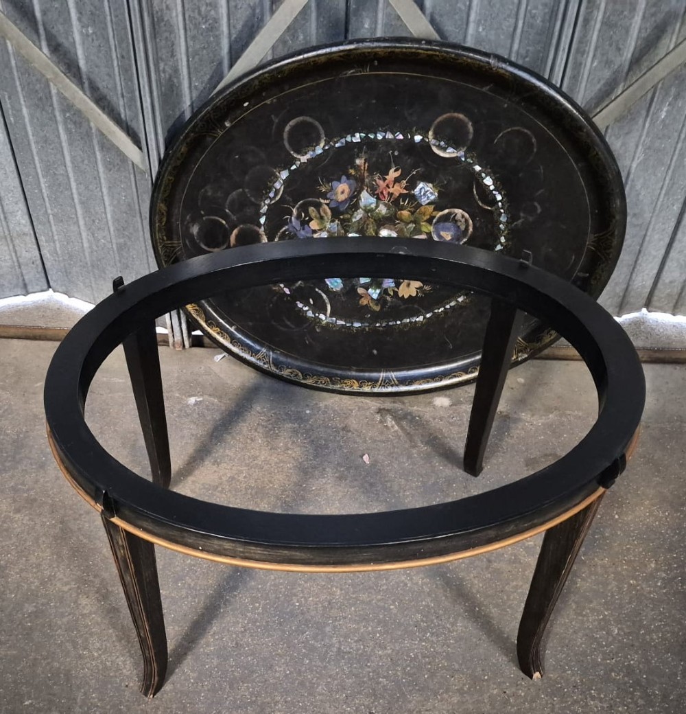 An oval black lacquered Victorian papier-mache tray table featuring mother-of-pearl floral inlay and gilt detailing on curved legs. View III