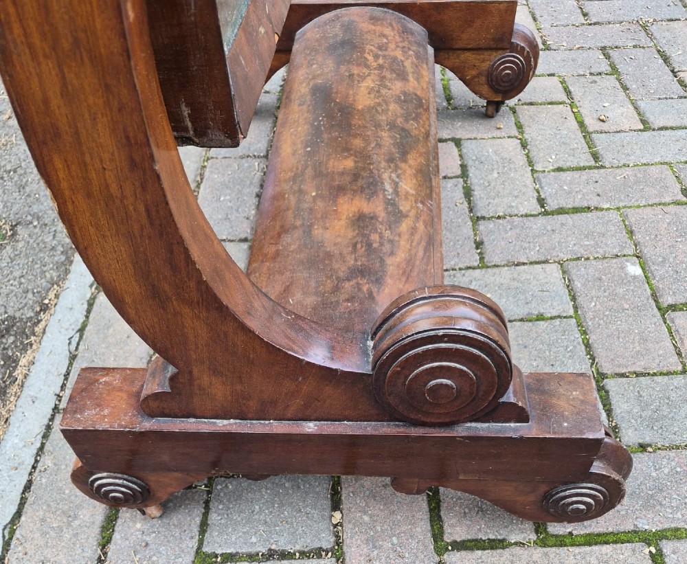 A Victorian mahogany freestanding cheval mirror featuring a rounded rectangular tilting frame mounted on carved upright pillars and a plinth base. View III