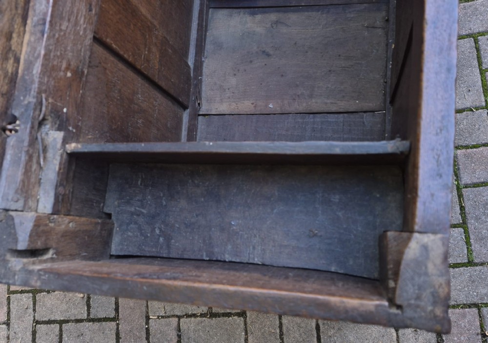 A dark carved oak coffer featuring a three-panel front with carved diamond lozenge patterns and an arcaded top rail. View IV