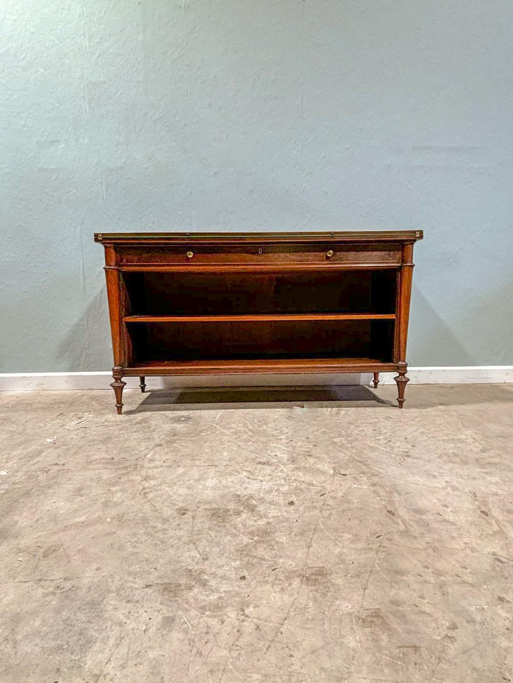 A low rectangular rosewood library bookcase featuring open shelving, a single upper drawer with brass knobs, and turned cylindrical feet.