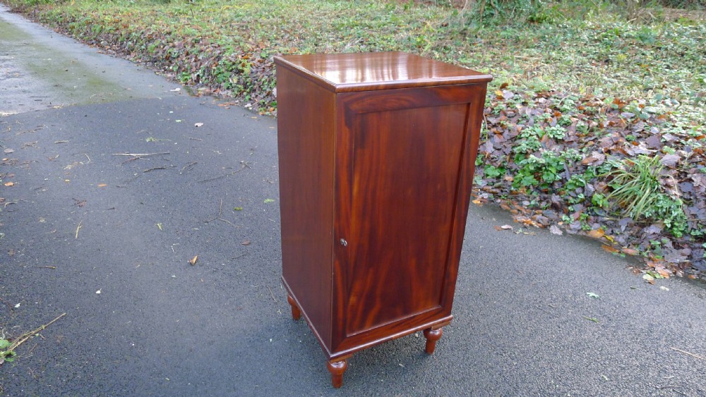A nineteenth-century mahogany collectors cabinet featuring an open panelled door revealing multiple shallow drawers with light-coloured knob handles. View II