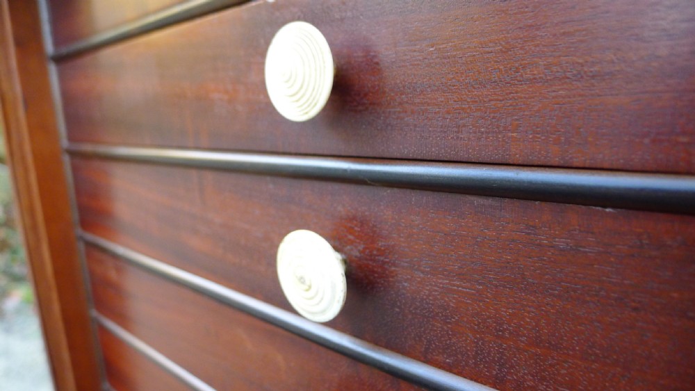 A nineteenth-century mahogany collectors cabinet featuring an open panelled door revealing multiple shallow drawers with light-coloured knob handles. View VI