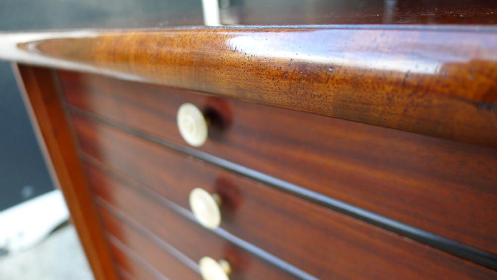A nineteenth-century mahogany collectors cabinet featuring an open panelled door revealing multiple shallow drawers with light-coloured knob handles. View XIV