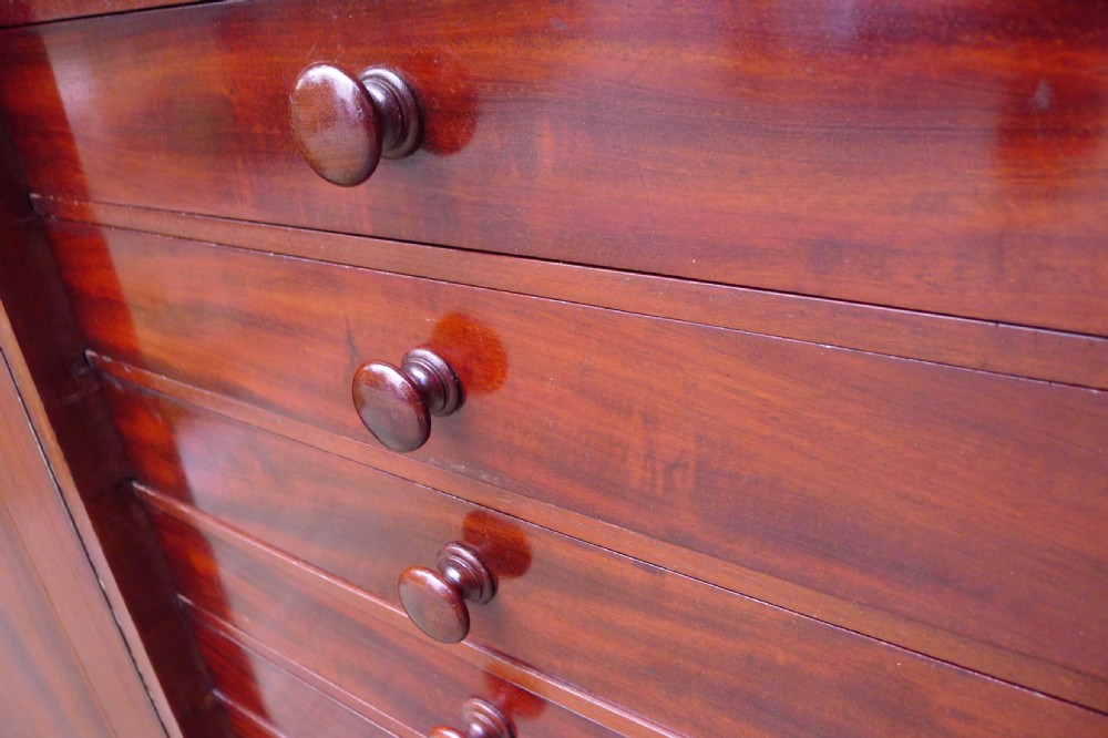 Victorian flame mahogany collectors cabinet featuring an upper shelf with a brass gallery and double doors opening to reveal multiple shallow drawers. View IV