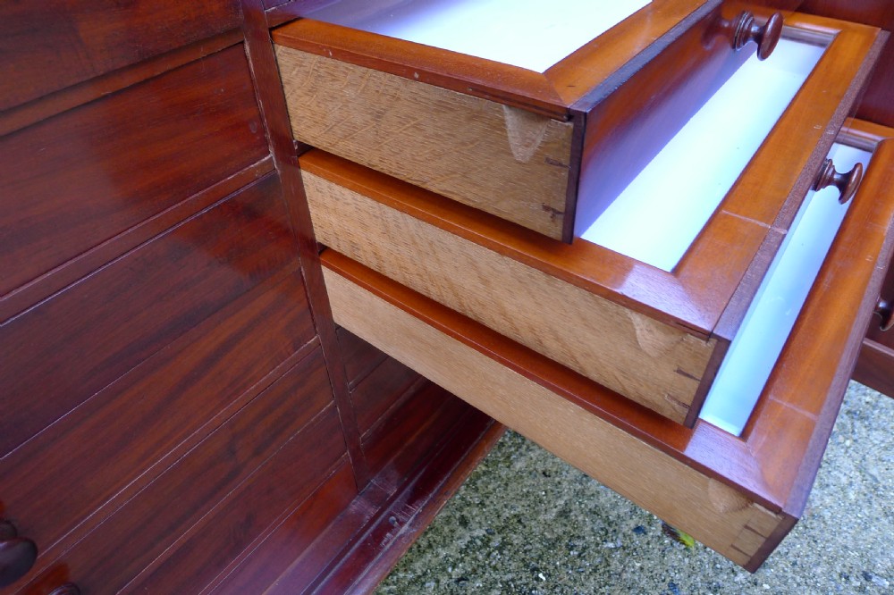Victorian flame mahogany collectors cabinet featuring an upper shelf with a brass gallery and double doors opening to reveal multiple shallow drawers. View XIII