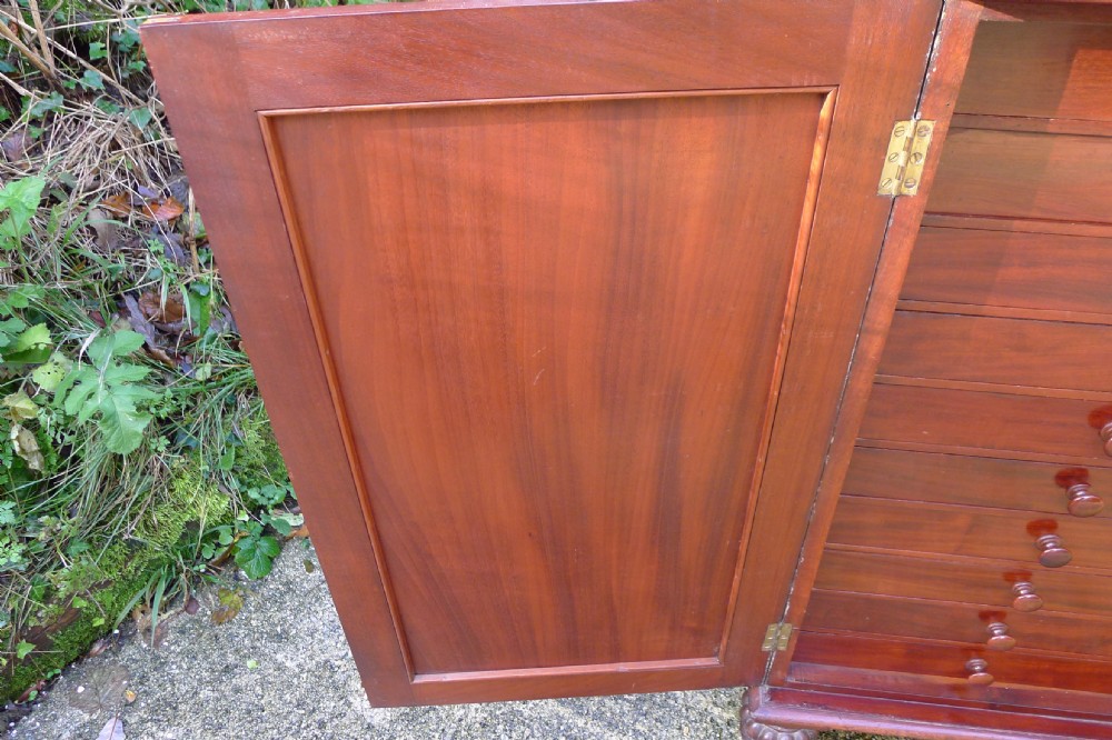 Victorian flame mahogany collectors cabinet featuring an upper shelf with a brass gallery and double doors opening to reveal multiple shallow drawers. View XVIII