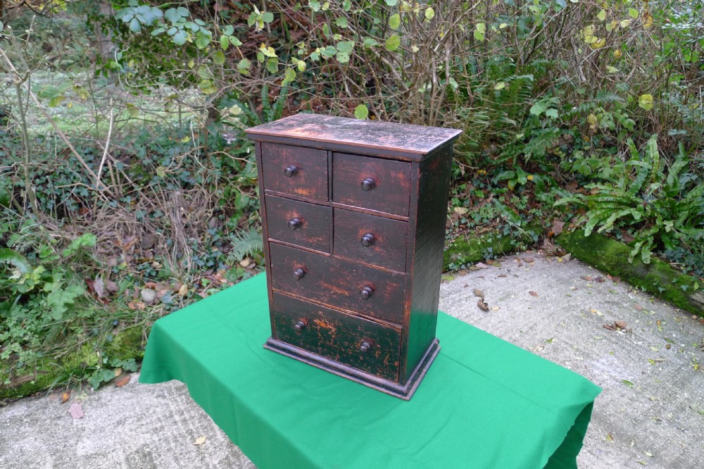 A small dark-stained deal wood collectors cabinet featuring six drawers with turned wooden knobs. View III