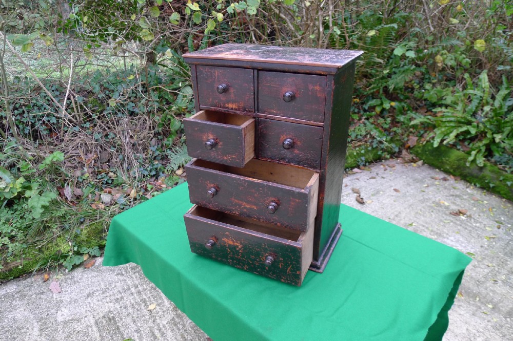 A small dark-stained deal wood collectors cabinet featuring six drawers with turned wooden knobs. View VI