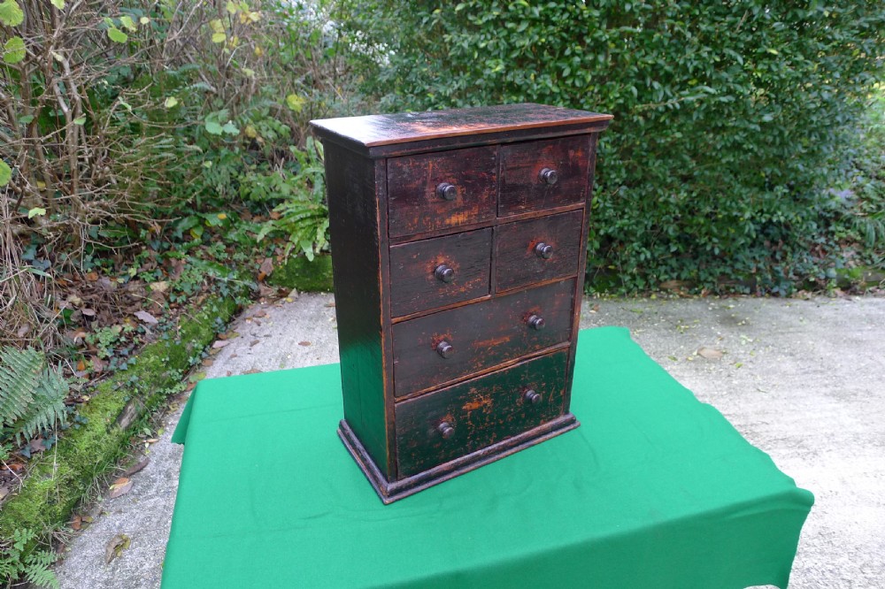 A small dark-stained deal wood collectors cabinet featuring six drawers with turned wooden knobs. View VII