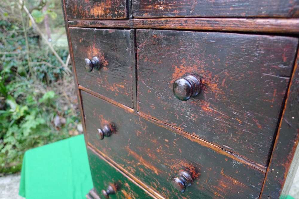 A small dark-stained deal wood collectors cabinet featuring six drawers with turned wooden knobs. View VIII