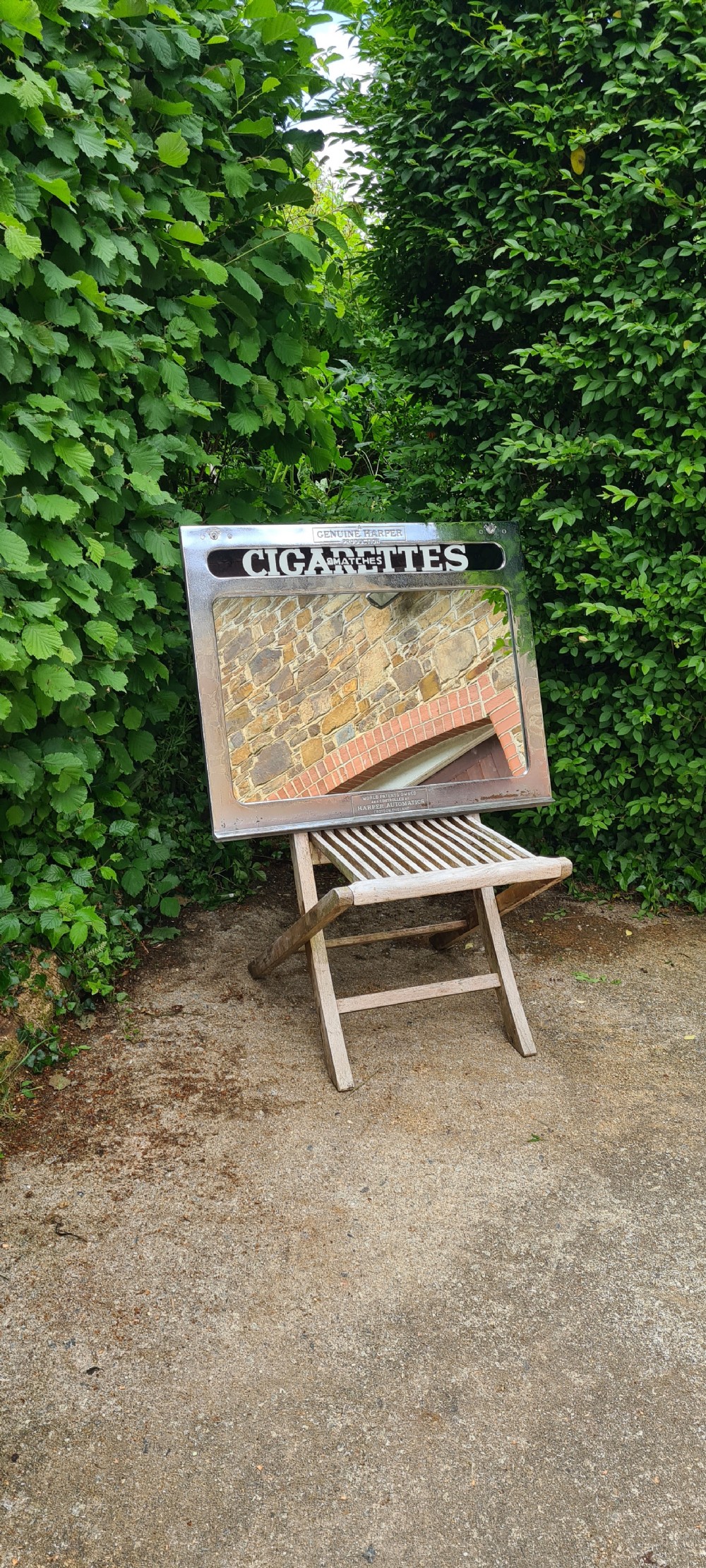A rectangular 1930s chrome advertising mirror with black lettered signage for cigarettes and matches by Harper Automatics. View III