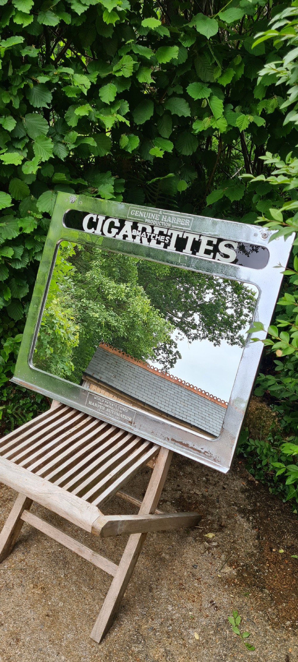 A rectangular 1930s chrome advertising mirror with black lettered signage for cigarettes and matches by Harper Automatics. View IV