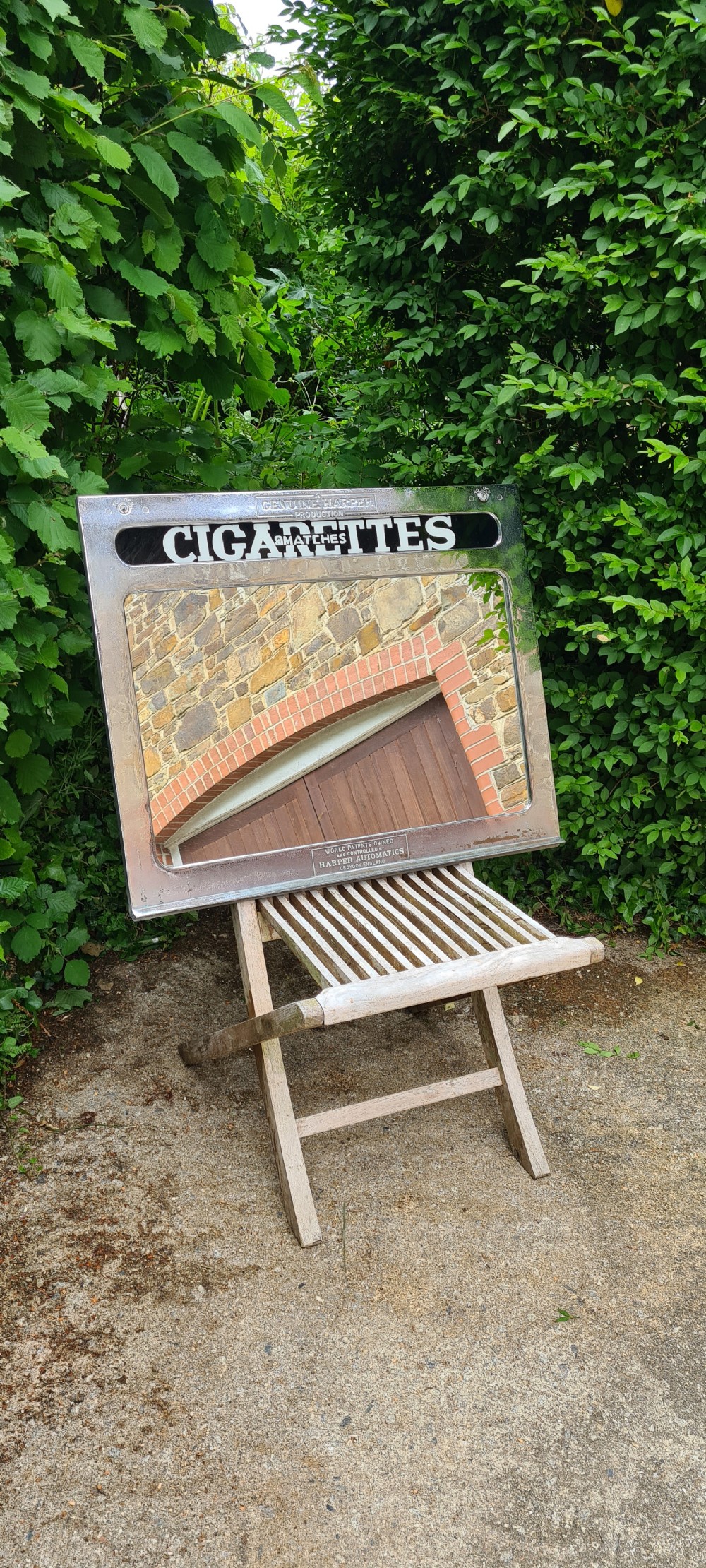 A rectangular 1930s chrome advertising mirror with black lettered signage for cigarettes and matches by Harper Automatics. View VII