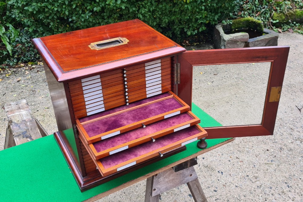 A Victorian mahogany tabletop microscope slide cabinet with a glass front door, numbered shallow drawers, and an inset brass carrying handle on top. View X